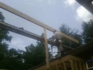 Carpenter setting a ridge beam over a new addition frame — Ice Dam Removal by Roofing Brothers in Lorraine