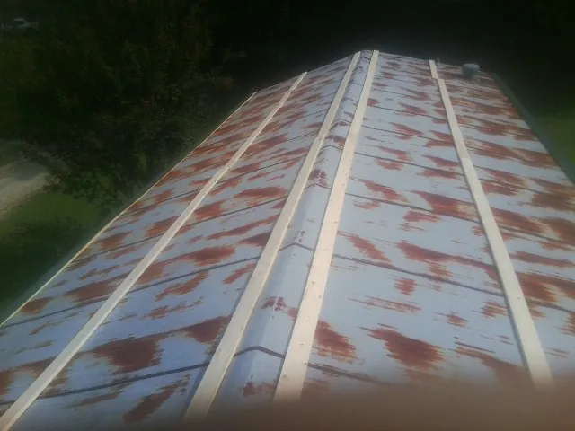 Rusted metal roof panels with new wood purlins before replacement — Storm Damage Roof Repair in Lorraine by Roofing Brothers